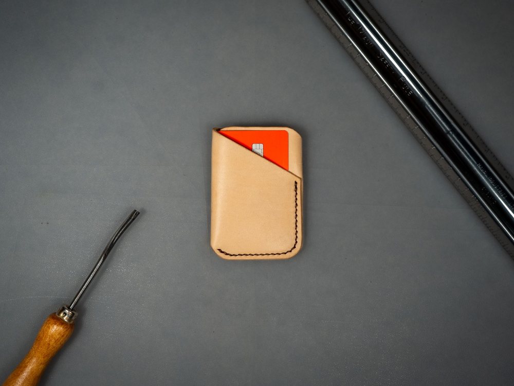Minimalist natural leather card wallet holding a card