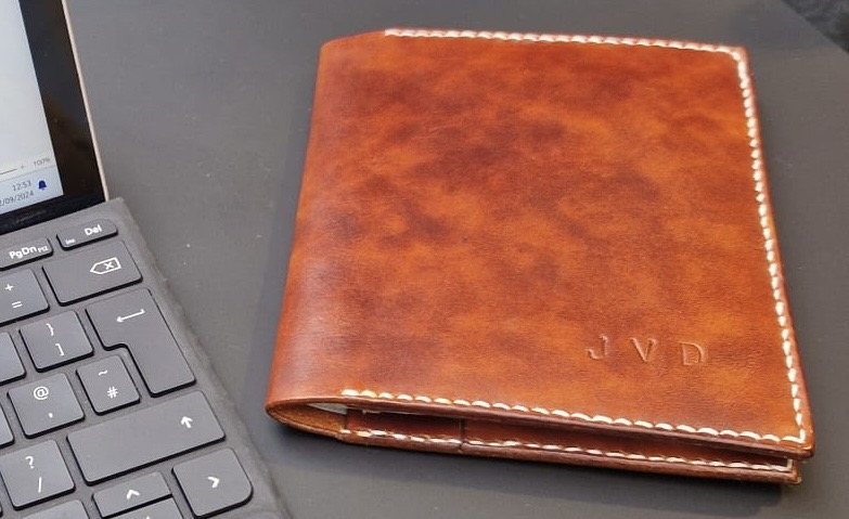 Tan leather passport cover with embossed initials